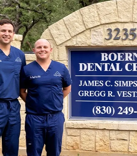Dr. Simpson and Dr. Vesta beside the stone Boerne Dental Center sign at 32350.