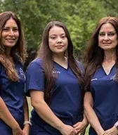 Three Boerne Dental Center team members smiling outdoors.